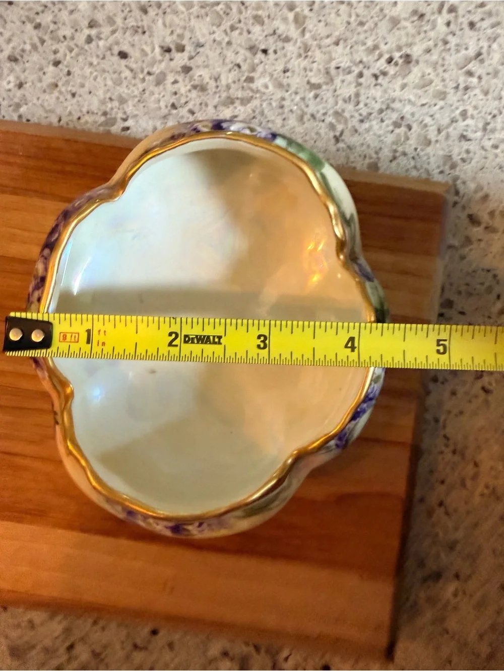 A hand-painted porcelain footed bowl with gilded rim and floral decoration.
